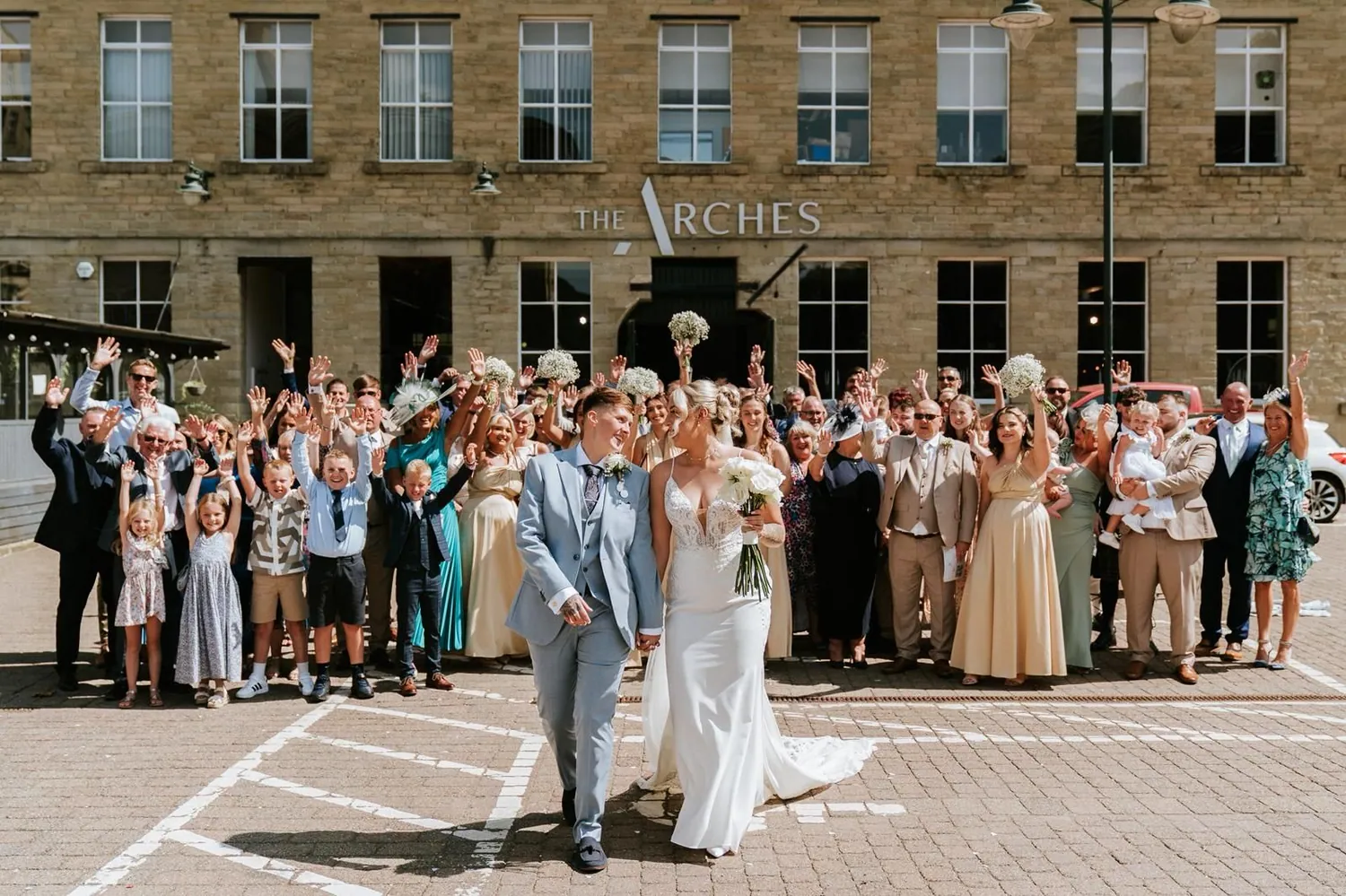 Newlyweds leaving The Arches to confetti beneath the venue sign