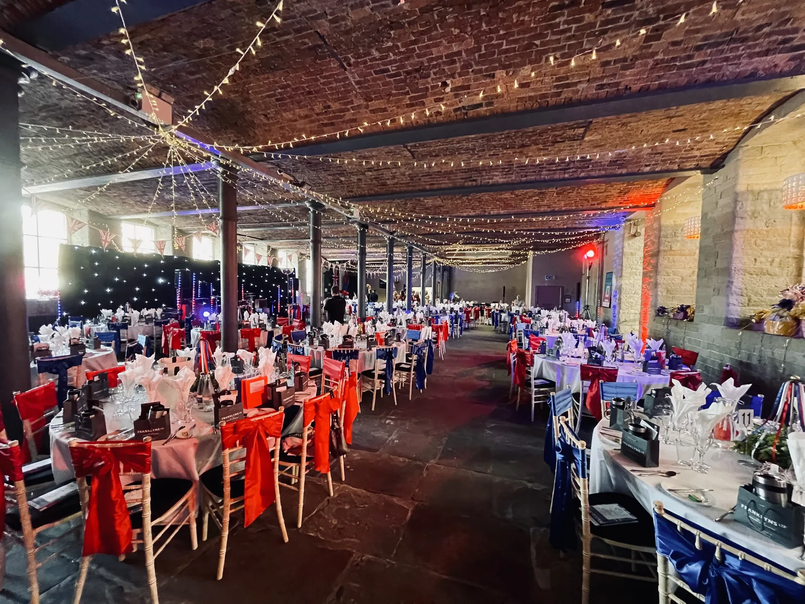 The hall at The Arches laid for a banquet beneath the fairy-light canopy